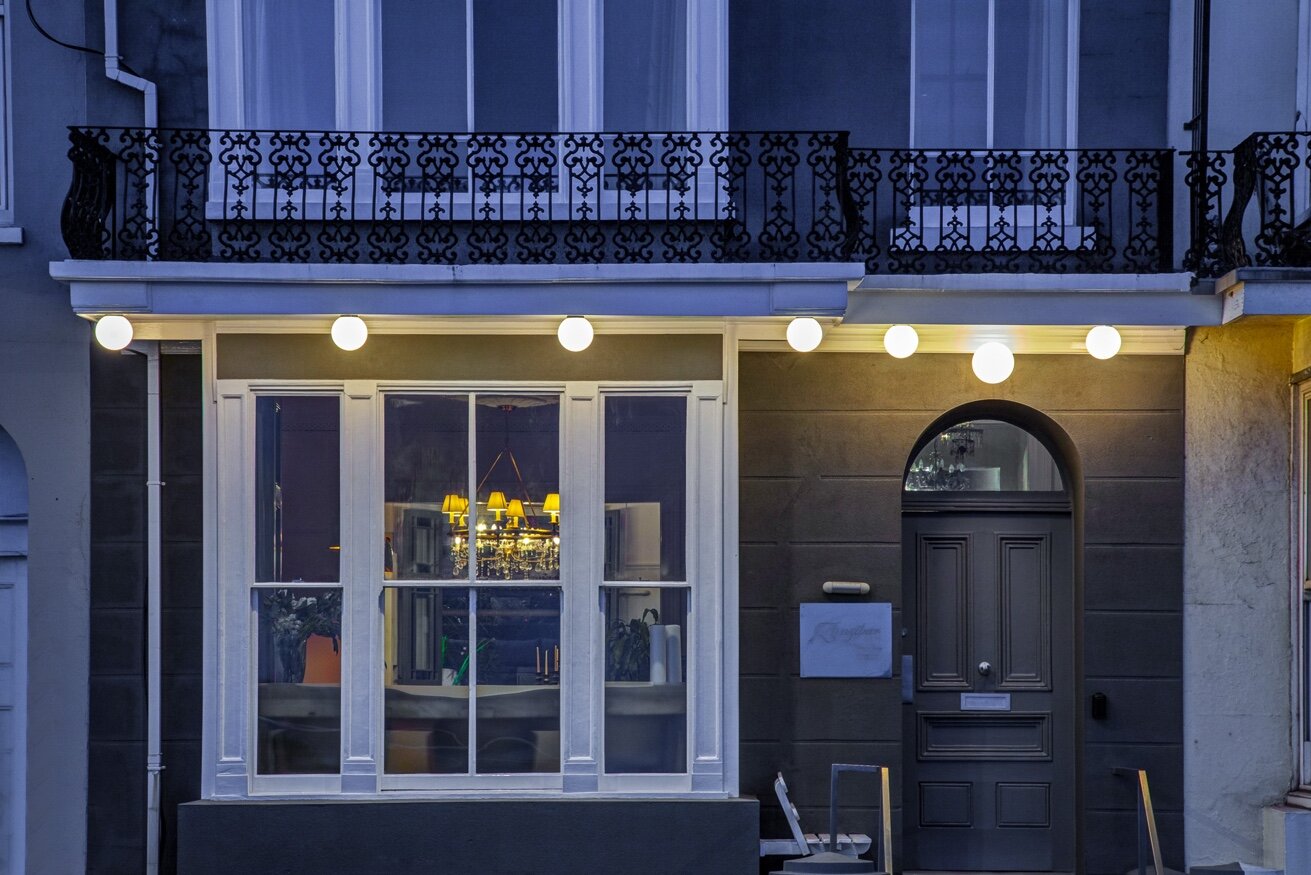 Zanzibar House exterior at dusk with globe lights and ornate balcony