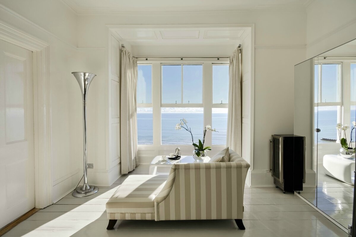 Antarctica Room — striped sofa and sea view with freestanding bath