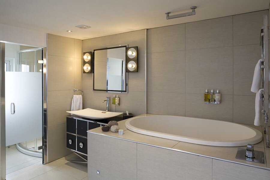 Manhattan Suite — Hollywood-mirror bathroom with oval bath and walk-in shower