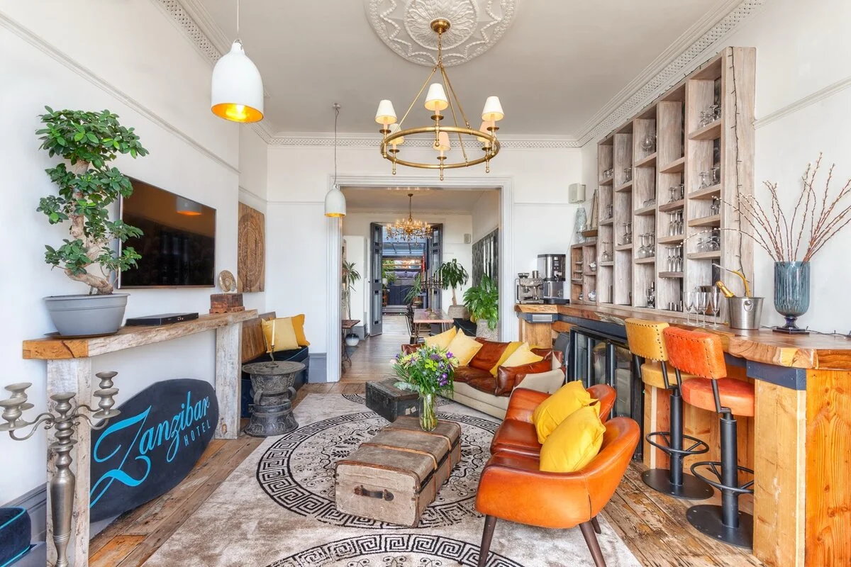 Zanzibar House lounge bar with leather chairs, bonsai tree and Zanzibar Hotel sign