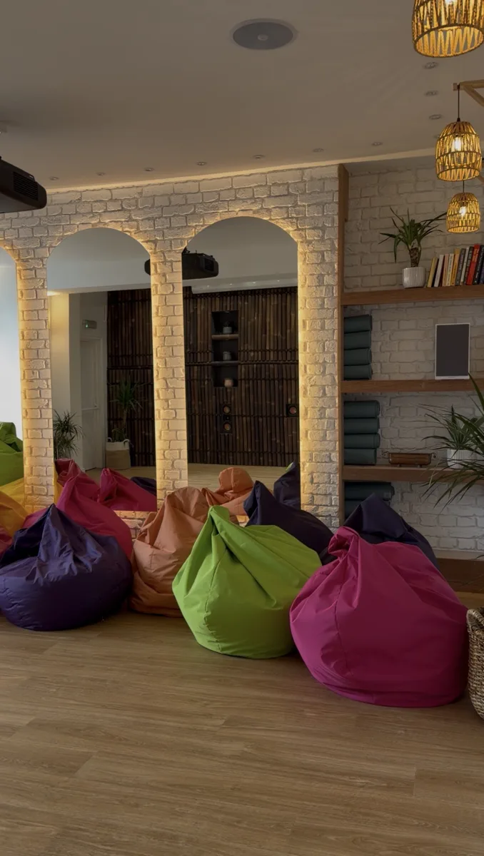 Zanzibar House basement studio with lit arched mirrors, bean bags, rolled yoga mats and rattan pendant lights